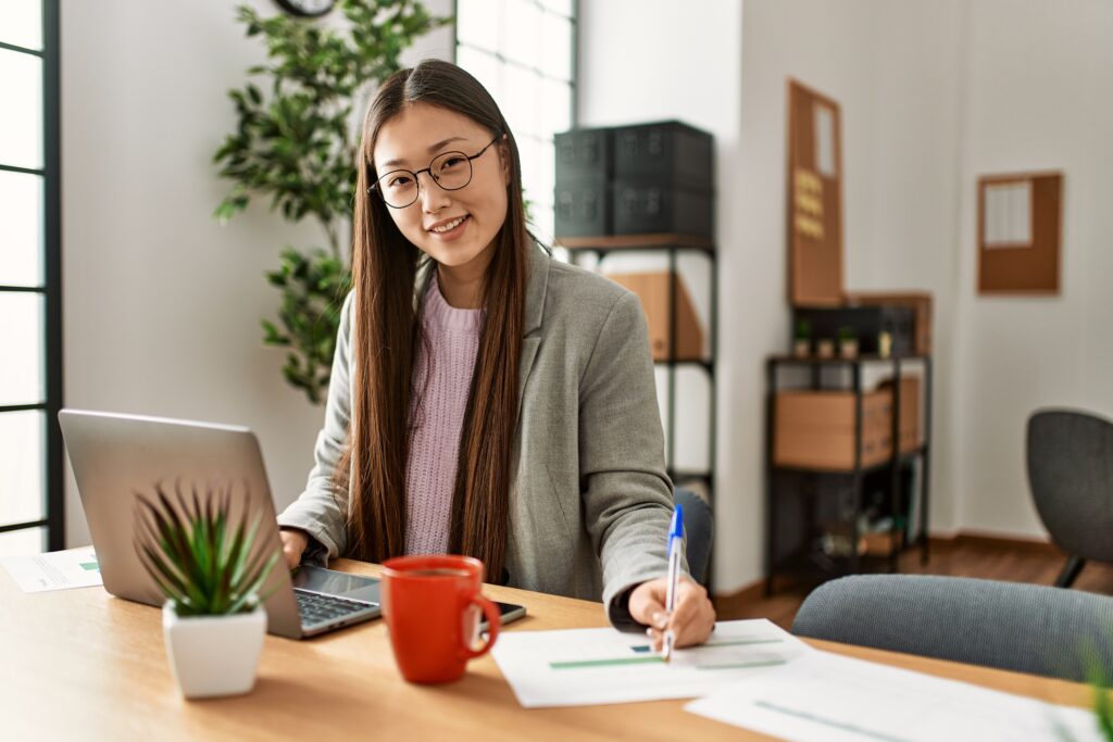 Young chinese businesswoman using laptop working at the office.