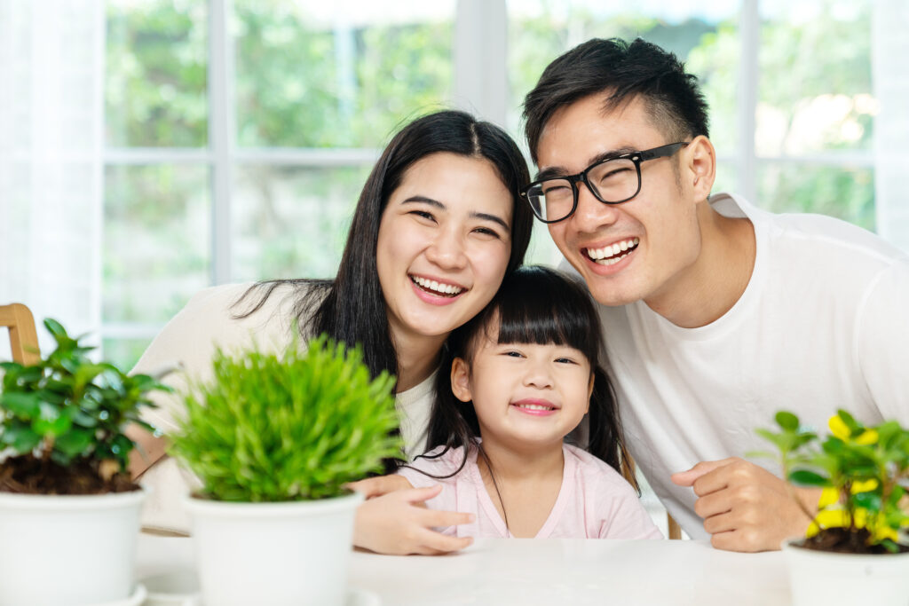 Portrait Of Young Cute Asian Family Three People At Home Smiling