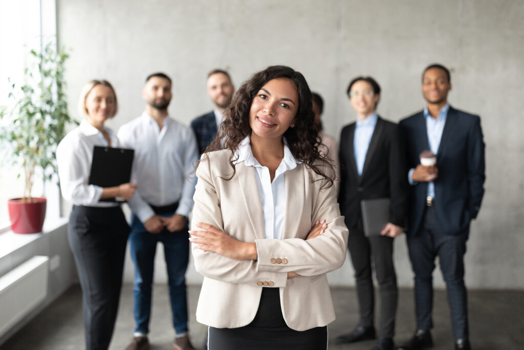 Successful Business Team. Mexican Businesswoman Standing In Fron