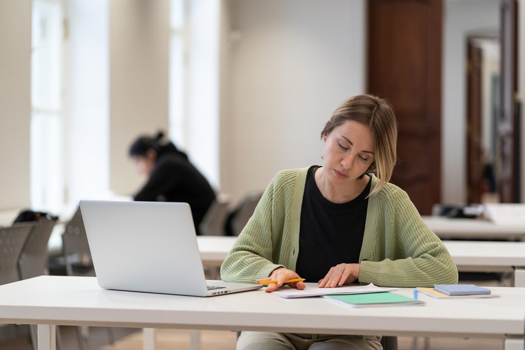Focused Middle-aged Female Student Prepare For Coursework In Lib