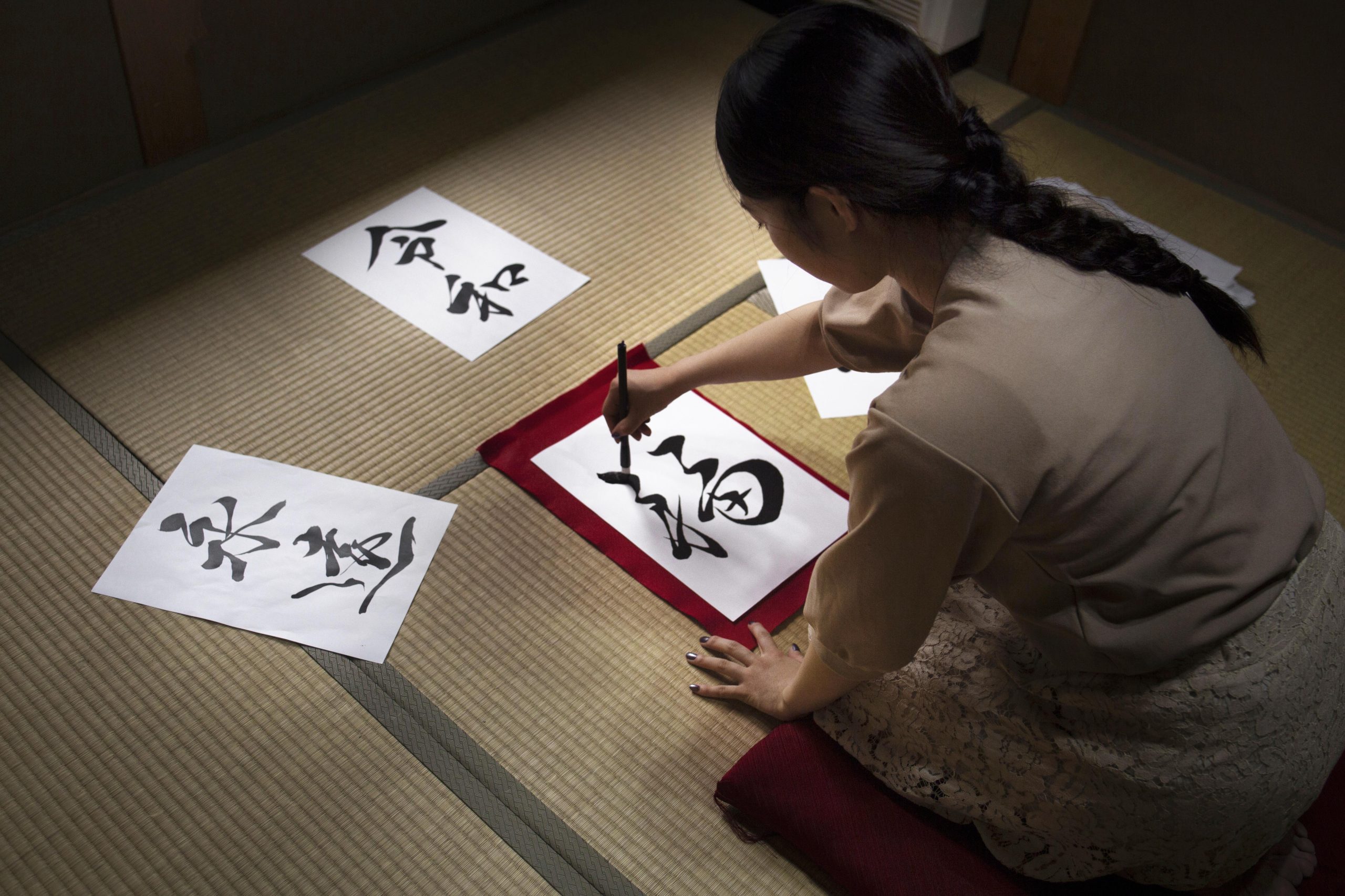 woman practicing japanese handwriting indoors